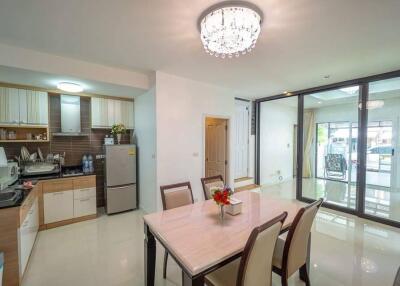 Modern kitchen and dining area with glass doors and bright lighting