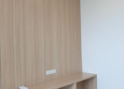 Minimalist bedroom with wooden wall panel and built-in desk