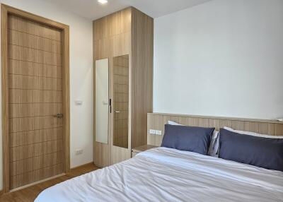 Modern bedroom with wooden furniture and a neatly made bed