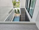 Glass balcony overseeing a pool and garden area