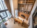 Loft-style living room with high ceiling and large windows.