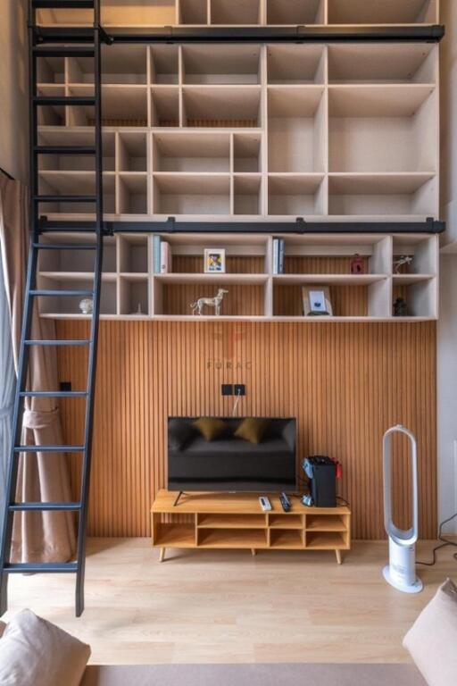 Modern living room with loft shelves, TV, and ladder