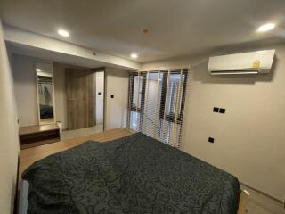 Bedroom with large bed, air conditioner, wooden floors, and ample lighting