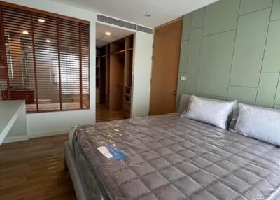Modern bedroom with a large bed and wooden flooring