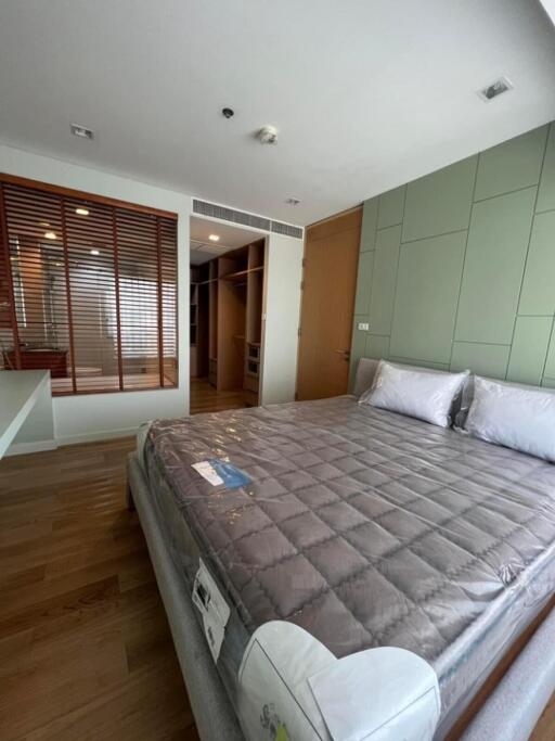 Modern bedroom with a large bed and wooden flooring