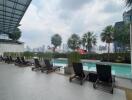 Outdoor swimming pool area with city skyline view