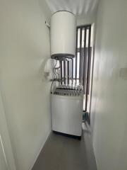 Compact laundry room with washing machine and water heater