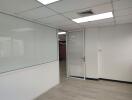 Modern office space with glass door and whiteboard