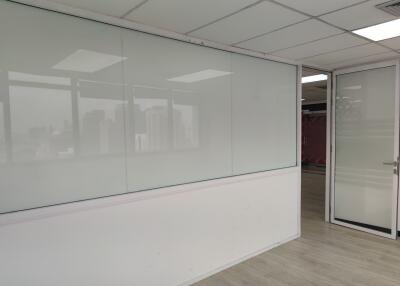 Empty office space with a glass partition and white walls