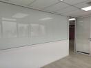 Empty office space with a glass partition and white walls