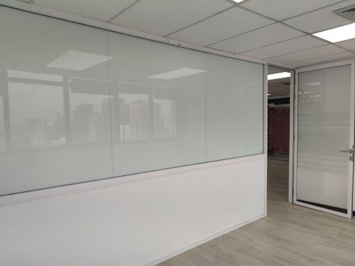 Empty office space with a glass partition and white walls