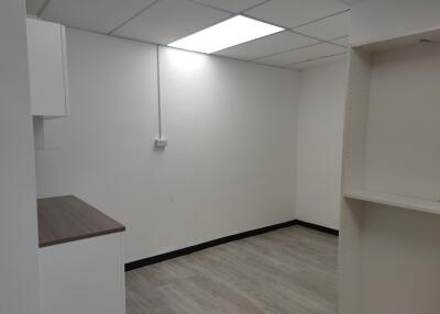 empty room with tiled ceiling and laminate flooring