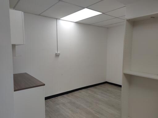 empty room with tiled ceiling and laminate flooring