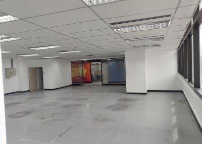 Empty office space with large windows and modern lighting