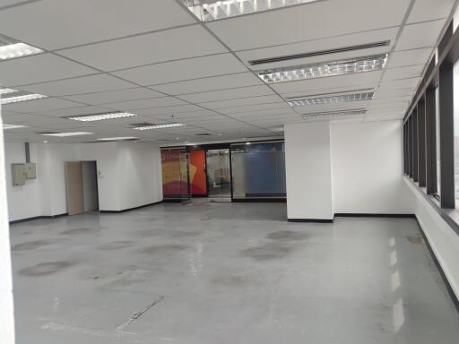 Empty office space with large windows and modern lighting