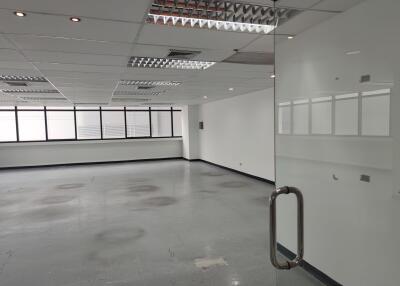 Empty office space with large windows and glass door