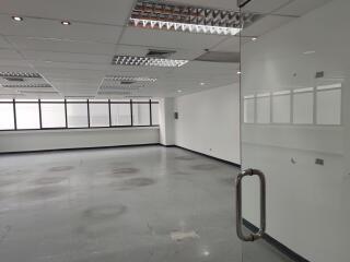 Empty office space with large windows and glass door