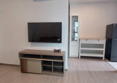 Modern living room with wall-mounted TV and wooden cabinets