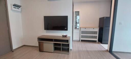 Modern living room with wall-mounted TV and wooden cabinets