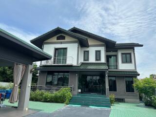 Exterior view of a two-story house with a large driveway and garage