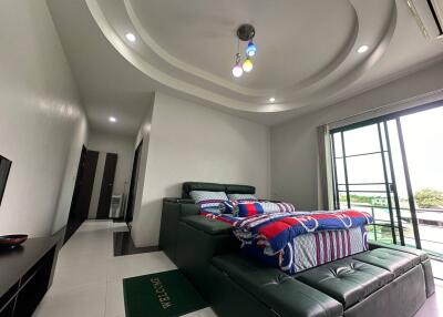 Modern bedroom with unique ceiling design and balcony access