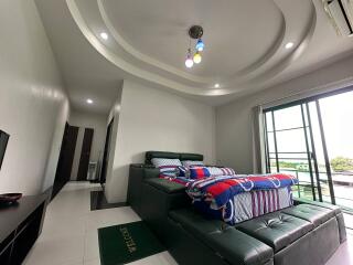 Modern bedroom with unique ceiling design and balcony access