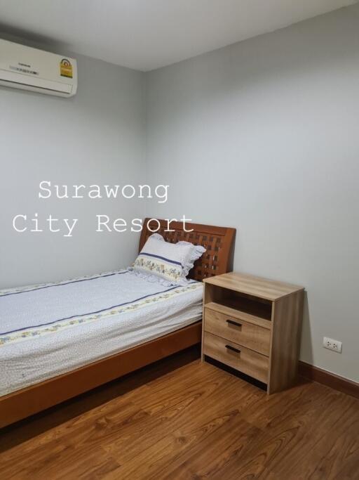 Simple bedroom with a single bed and nightstand at Surawong City Resort