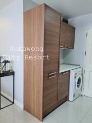 Laundry area with wooden cabinets and washing machine