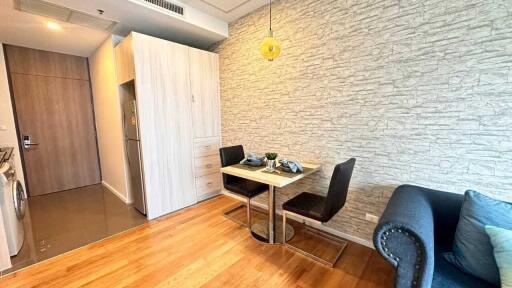 Compact dining area with table and chairs adjacent to kitchen and living space