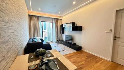 Modern living room with dining area, large windows, and wooden flooring