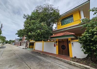 Two-story house with yellow exterior and driveway