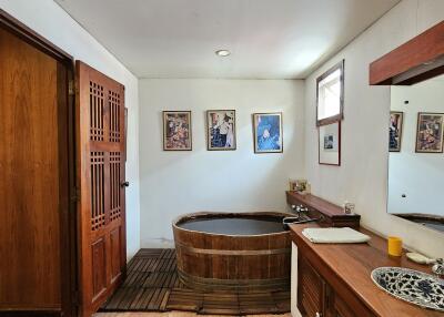 Cozy bathroom with a wooden soaking tub and large mirror