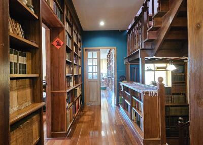 Hallway with wooden bookshelves and stairs