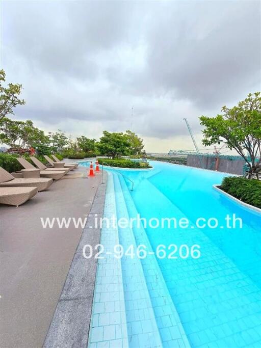 Swimming pool area with lounge chairs and trees