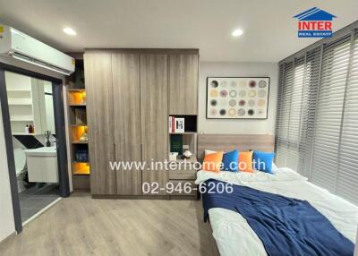 Modern bedroom with wooden floor, large wardrobe, and decorations