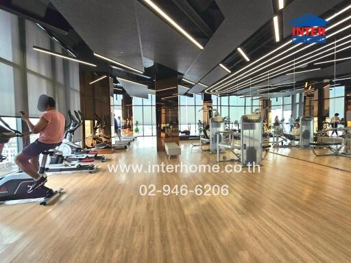 Modern gym with various exercise equipment and hardwood floors