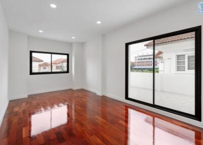 Spacious living room with large windows and polished wooden floor