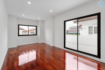 Spacious living room with large windows and polished wooden floor