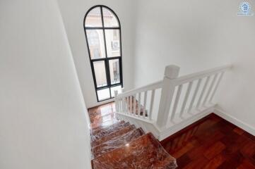 Indoor staircase with wooden steps and white railing