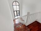 Indoor staircase with wooden steps and white railing