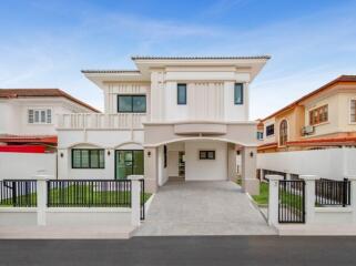 Modern two-story house exterior with gated driveway