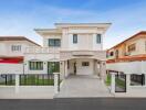 Modern two-story house exterior with gated driveway