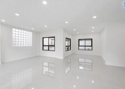 Spacious living area with large windows and tiled flooring