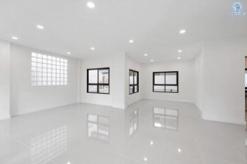 Spacious living area with large windows and tiled flooring