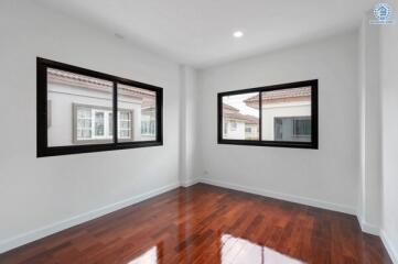 Empty bedroom with hardwood floor and large windows