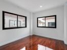 Empty bedroom with hardwood floor and large windows