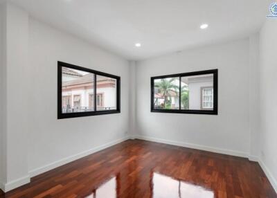 Empty room with wooden flooring and large windows