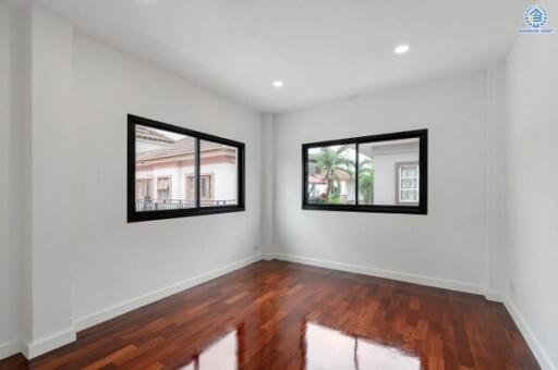 Empty room with wooden flooring and large windows