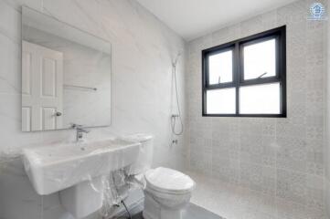 Modern bathroom with large window, shower, sink, and toilet