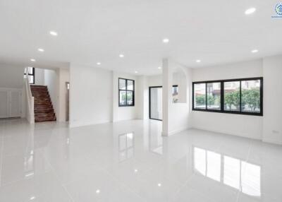 Spacious open living area with large windows and stairway